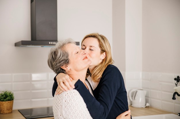 a mother and daughter embracing in a kitchen